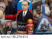 Символы России - матрешка, балалайка и изображение президента Путина на прилавке сувенирного магазина на Тверской улице в центре города Москвы, Россия (2019 год). Редакционное фото, фотограф Николай Винокуров / Фотобанк Лори