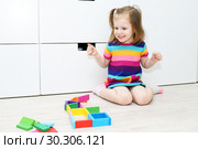 Little girl playing with educational toy at home on the floor. Стоковое фото, фотограф ivolodina / Фотобанк Лори