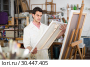 Man near easel painting on canvas. Стоковое фото, фотограф Яков Филимонов / Фотобанк Лори