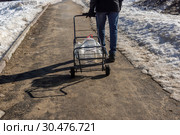 Весенним утром городской житель идет с пластиковыми канистрами на родник за водой (2019 год). Стоковое фото, фотограф Sergei Gorin / Фотобанк Лори
