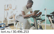 Group of people exercising with weight and on simulators in gym. Стоковое видео, видеограф Яков Филимонов / Фотобанк Лори