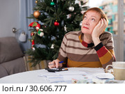 Mature woman calculates utility costs in the new year. Стоковое фото, фотограф Яков Филимонов / Фотобанк Лори