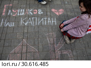 Болельщица футбольного клуба Спартак пишет мелками на площади перед стадионом в городе Москве "Глушаков наш капитан", Россия (2019 год). Редакционное фото, фотограф Николай Винокуров / Фотобанк Лори