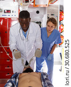 Rescue team making defibrillation to patient. Стоковое фото, фотограф Яков Филимонов / Фотобанк Лори