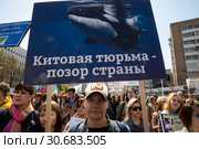 Женщина держит плакат с надписью "Китовая тюрьма - позор страны" на первомайском марше в защиту животных по центральным улицам города Москвы, Россия (2019 год). Редакционное фото, фотограф Николай Винокуров / Фотобанк Лори