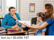 Офисный специалист отказывается делать перерасчет счетов, когда на прием пришла многодетная мать. Стоковое фото, фотограф Иванов Алексей / Фотобанк Лори
