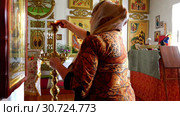 Servant of the church chandelier lights from candles and baptized (2016 год). Редакционное видео, видеограф Aleksandr Sulimov / Фотобанк Лори