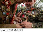 Ветеран Афганской войны помогает прикрепить памятную медаль "30 лет Вывода войск из Афганистана" в сквере Воинов-интернационалистов на улице Ленина в центре города Севастополя 9 мая 2019 года. Редакционное фото, фотограф Николай Винокуров / Фотобанк Лори