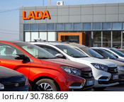 Ряд новых автомобилей марки Lada у здания дилера (2018 год). Редакционное фото, фотограф Вячеслав Палес / Фотобанк Лори