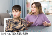 Mother and offended son arguing in domestic interior. Стоковое фото, фотограф Яков Филимонов / Фотобанк Лори