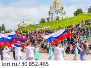Russia Samara May 2019: Beautifully dressed schoolchildren waving the Russian flag at an open city festival. The last school bell . Редакционное фото, фотограф Акиньшин Владимир / Фотобанк Лори