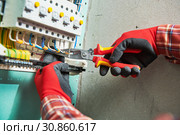 Electrician works with pliers in switchbox. current breaker installation. Стоковое фото, фотограф Дмитрий Калиновский / Фотобанк Лори