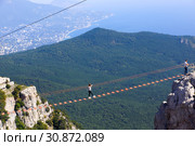 Алупка, Крым - 21 сентября 2018. Подвесная лестница на горе Ай-Петри. Туристы идут по висящей лестнице между зубцами горы. На горизонте Ялта. Редакционное фото, фотограф ирина реброва / Фотобанк Лори