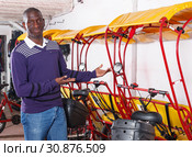 Happy driver of pedicab offering touristic tour. Стоковое фото, фотограф Яков Филимонов / Фотобанк Лори