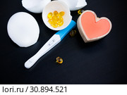 Infertility. Negative pregnancy test, pills and heart, eggshell on black. Стоковое фото, фотограф Papoyan Irina / Фотобанк Лори