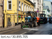 Большой Сухаревский переулок. Трактора "Беларус" с цистерной воды моют улицу. Москва (2019 год). Редакционное фото, фотограф Александр Щепин / Фотобанк Лори