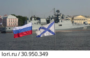 Российский и Андреевский флаги на фоне фрегата "Адмирал Макаров". День ВМФ в Санкт-Петербурге (2018 год). Редакционное видео, видеограф Виктор Карасев / Фотобанк Лори