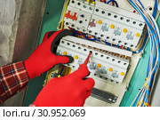 Electrician works with pliers in switchbox. current breaker installation. Стоковое фото, фотограф Дмитрий Калиновский / Фотобанк Лори