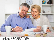 Mature friends are discussing and studying important contract. Стоковое фото, фотограф Яков Филимонов / Фотобанк Лори