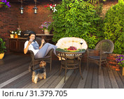 Woman with a glass of wine resting in a chair next to the dog. Стоковое фото, фотограф Элина Гаревская / Фотобанк Лори