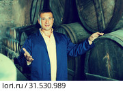 Happy worker posing with wine barrels. Стоковое фото, фотограф Яков Филимонов / Фотобанк Лори