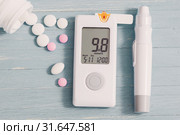 glucometer and pills on gray wooden background. Стоковое фото, фотограф Майя Крученкова / Фотобанк Лори