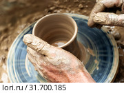 Potter's hands mold pottery on a rotating wheel. Стоковое фото, фотограф Евгений Харитонов / Фотобанк Лори