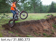 Motorcycle rider Caucasian man jumping in sandy pit with his trial bike, copy space. Стоковое фото, фотограф Кекяляйнен Андрей / Фотобанк Лори