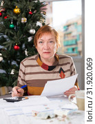 Mature woman calculates utility costs in the new year. Стоковое фото, фотограф Яков Филимонов / Фотобанк Лори