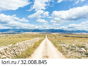 Dirt road leading trough dry rocky Mediterranean coastal lanscape of Pag island, Croatia in summertime. Стоковое фото, фотограф Matej Kastelic / Фотобанк Лори