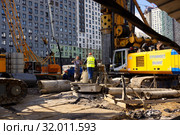 Строительство участка северо-западной хорды в Москве. Пересечение улиц Нижние Мневники и Карамышевская набережная. Рабочие у свае-бурильной машины. 2 июня 2019 года. Редакционное фото, фотограф ирина реброва / Фотобанк Лори