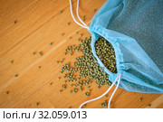 Top view of green mung bean in blue reusable package on wooden background. Healthy eating concept. Стоковое фото, фотограф Ольга Балынская / Фотобанк Лори