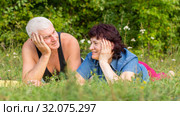 Mature beautiful couple in love on a green lawn in a park on a summer sunny day. Стоковое фото, фотограф Акиньшин Владимир / Фотобанк Лори