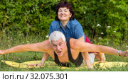 Mature beautiful couple in love on a green lawn in a park on a summer sunny day. Стоковое фото, фотограф Акиньшин Владимир / Фотобанк Лори