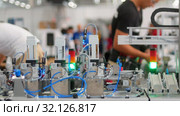 Modern technological exhibition - young people doing something on the background. Стоковое видео, видеограф Константин Шишкин / Фотобанк Лори