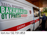 Пункт бесплатной вакцинации от гриппа в специальном автомобиле скорой помощи у метро в городе Москве, Россия (2019 год). Редакционное фото, фотограф Николай Винокуров / Фотобанк Лори