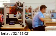 Modern technological exhibition - a man worker fixes computer - 3D printer in the foreground. Стоковое видео, видеограф Константин Шишкин / Фотобанк Лори