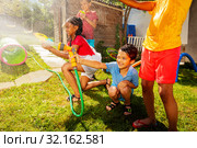 Group of kids play water gun fight game outside. Стоковое фото, фотограф Сергей Новиков / Фотобанк Лори