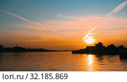 A beautiful view on the sunset sky - the sun sets over the calm water. Стоковое видео, видеограф Константин Шишкин / Фотобанк Лори