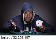 Young man wearing a hoodie with cards and chips gambling. Стоковое фото, фотограф Elnur / Фотобанк Лори