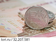 Деньги. Российские рублевые монетки на фоне сторублевых банкнот. Стоковое фото, фотограф E. O. / Фотобанк Лори