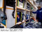 Сотрудник детской неотложной скорой помощи внутри автомобиля для оказания реанимационной помощи детам в городе Москве, Россия (2019 год). Редакционное фото, фотограф Николай Винокуров / Фотобанк Лори
