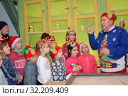 Пожилой мужчина показывает стеклянную заготовку. Детская экскурсия на фабрике елочных игрушек. Кентшин, Польша (2018 год). Редакционное фото, фотограф Ирина Борсученко / Фотобанк Лори
