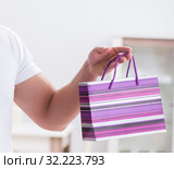 Young man with gift bag at home preparing suprise for wife. Стоковое фото, фотограф Elnur / Фотобанк Лори