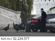 Семинарист прячется от индюков в Высоцком монастыре города Серпухова (2019 год). Редакционное фото, фотограф Дмитрий Неумоин / Фотобанк Лори