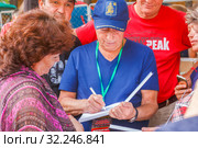 Russia, Samara, July 2016: Distribution of Alexander Gorodnitsky's autographs, at the Grushinsky festival on Mastryukovskie lakes on a summer day. Редакционное фото, фотограф Акиньшин Владимир / Фотобанк Лори