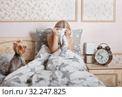 Расстроенная женщина сидит в кровати, уткнувшись в одеяло. Депрессия. Стоковое фото, фотограф Элина Гаревская / Фотобанк Лори