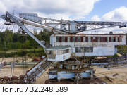 Old rusty multi bucket excavator, giant stacker, absetzer in sandy career. Стоковое фото, фотограф Mikhail Starodubov / Фотобанк Лори