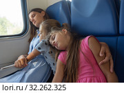 Заснувшие мама и дочки уснули в вагоне электропоезда. Стоковое фото, фотограф Иванов Алексей / Фотобанк Лори