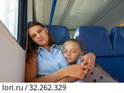 Мама с дочкой спят в сидячем вагоне электропоезда. Стоковое фото, фотограф Иванов Алексей / Фотобанк Лори